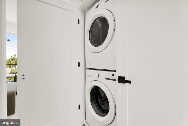 clothes washing area featuring stacked washer and dryer