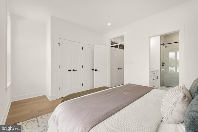 bedroom with ensuite bath and light hardwood / wood-style floors