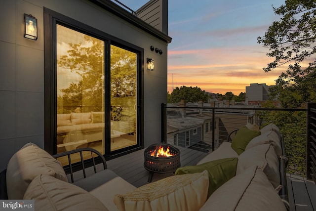 balcony at dusk with an outdoor living space with a fire pit