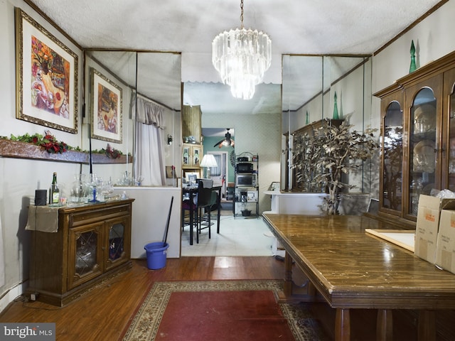 dining area with a chandelier, a textured ceiling, and hardwood / wood-style flooring