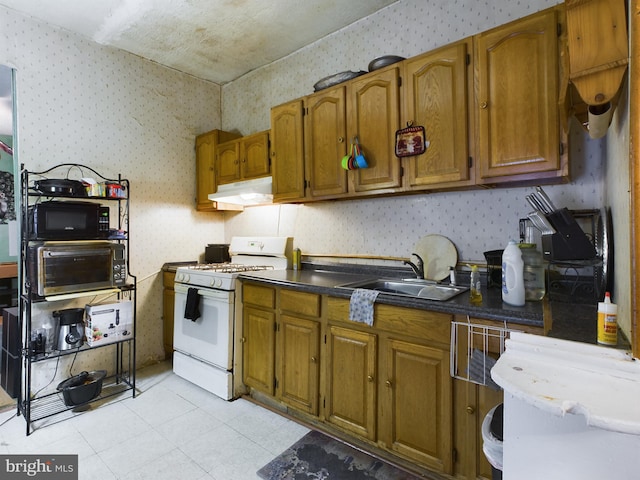 kitchen featuring white gas range and sink