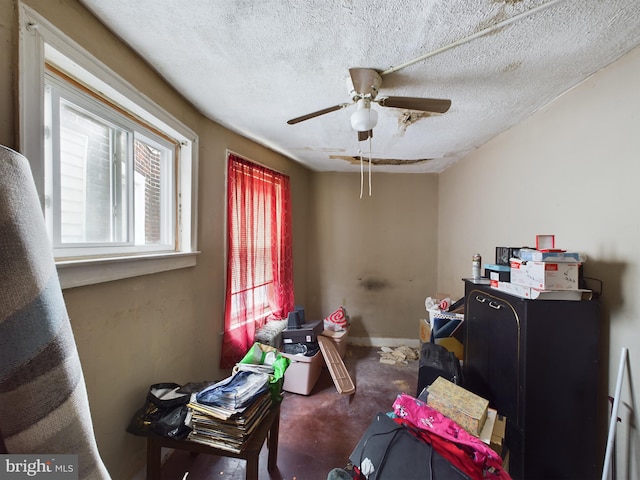 interior space featuring a textured ceiling and ceiling fan