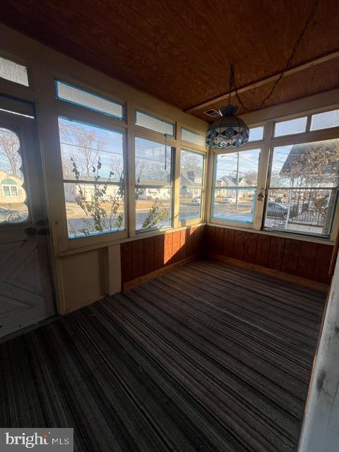 unfurnished sunroom with a healthy amount of sunlight and wood ceiling