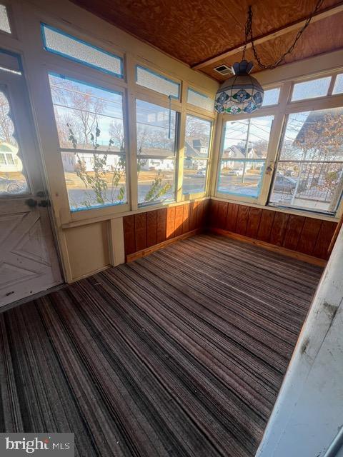 unfurnished sunroom with wood ceiling