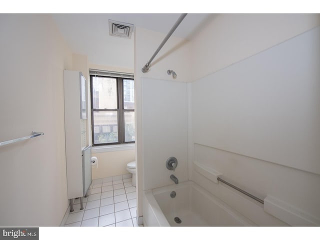 bathroom featuring tile patterned floors, toilet, and tub / shower combination