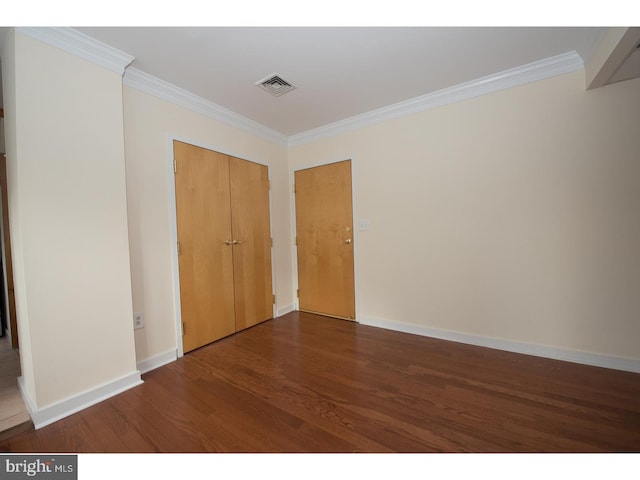 unfurnished bedroom with a closet, dark hardwood / wood-style floors, and ornamental molding