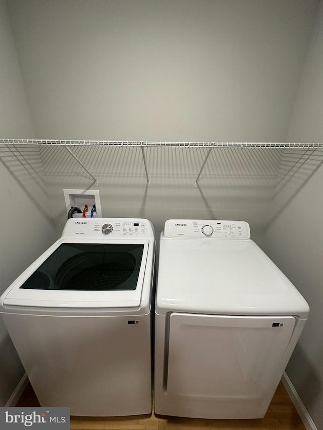 washroom with hardwood / wood-style floors and independent washer and dryer