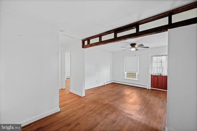 unfurnished living room featuring hardwood / wood-style flooring, ceiling fan, and a baseboard heating unit