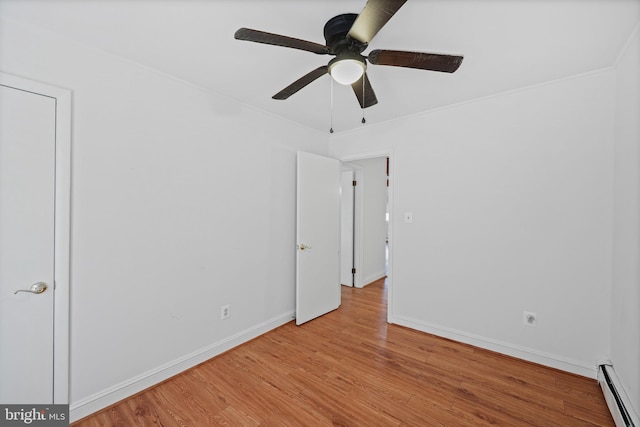 empty room featuring light hardwood / wood-style floors and a baseboard heating unit