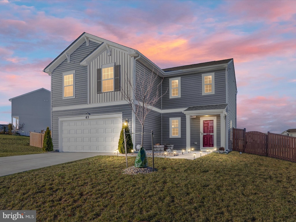 front of property with a garage and a lawn