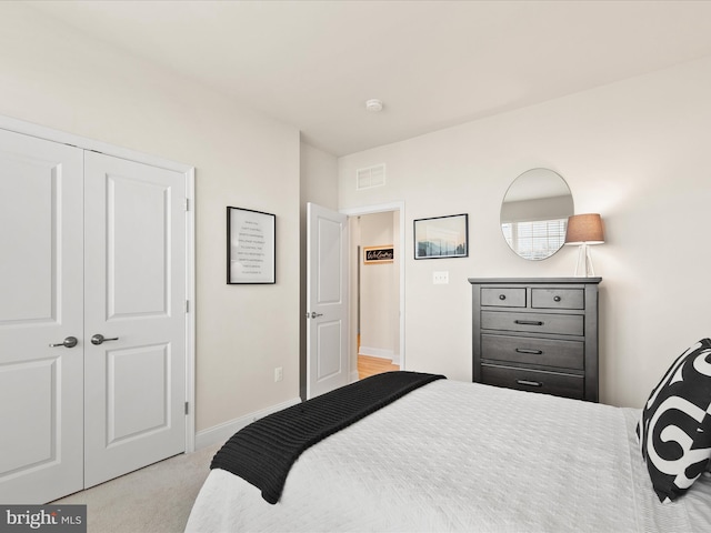 bedroom with a closet and light colored carpet