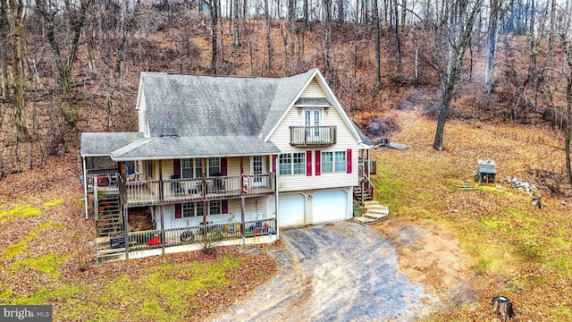 view of front of property with a porch, a balcony, and a garage