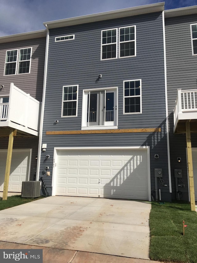 view of front of property featuring a garage and central AC