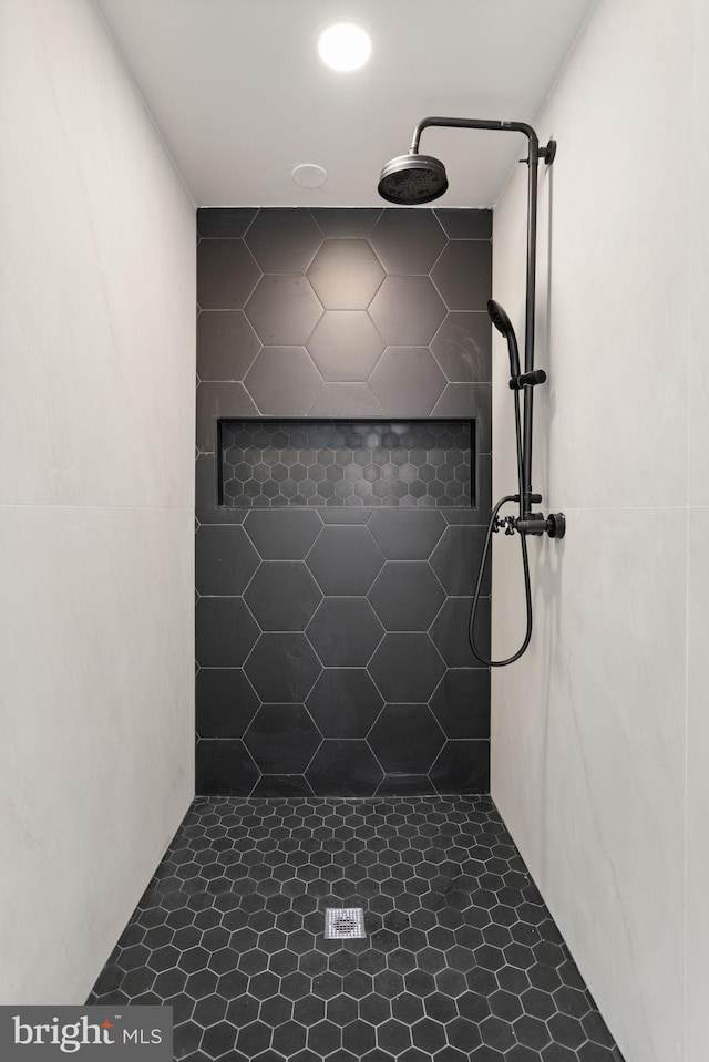 bathroom with tile patterned flooring and tiled shower