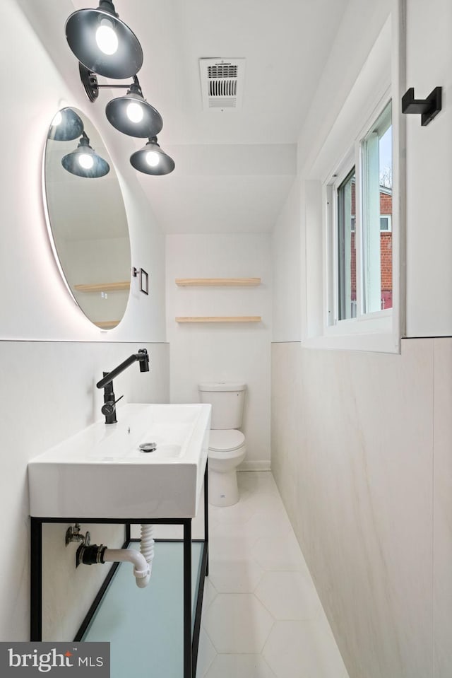 bathroom with tile patterned flooring, vanity, and toilet