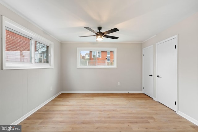 spare room with ceiling fan, light wood-type flooring, and ornamental molding