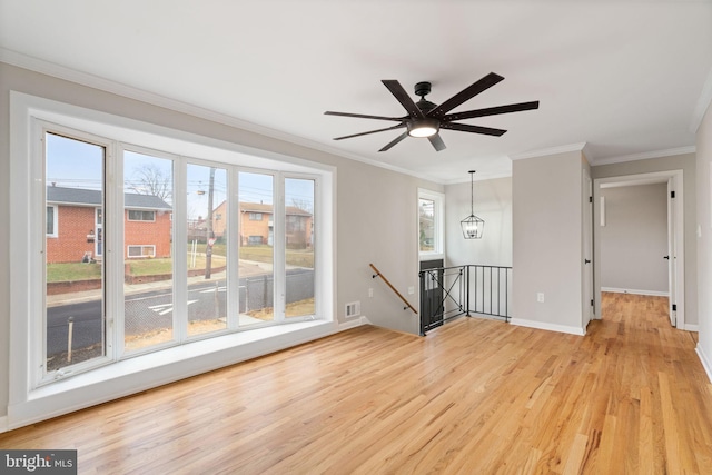 unfurnished room with ceiling fan with notable chandelier, light hardwood / wood-style flooring, and ornamental molding