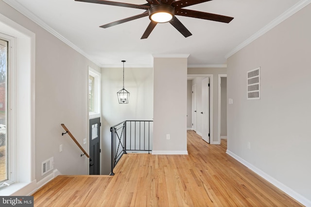 interior space featuring a chandelier, a wealth of natural light, crown molding, and light hardwood / wood-style floors