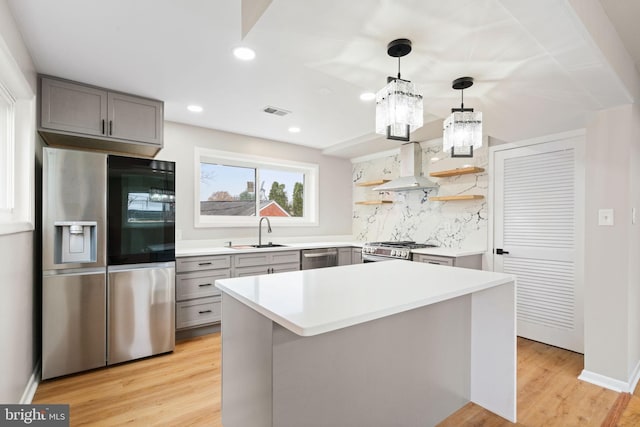 kitchen featuring backsplash, sink, light wood-type flooring, and appliances with stainless steel finishes