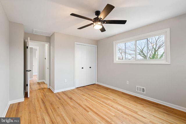 unfurnished bedroom with ceiling fan, light wood-type flooring, and a closet