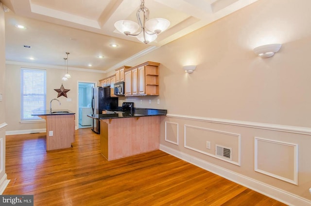 kitchen featuring hardwood / wood-style floors, sink, electric range, decorative light fixtures, and kitchen peninsula