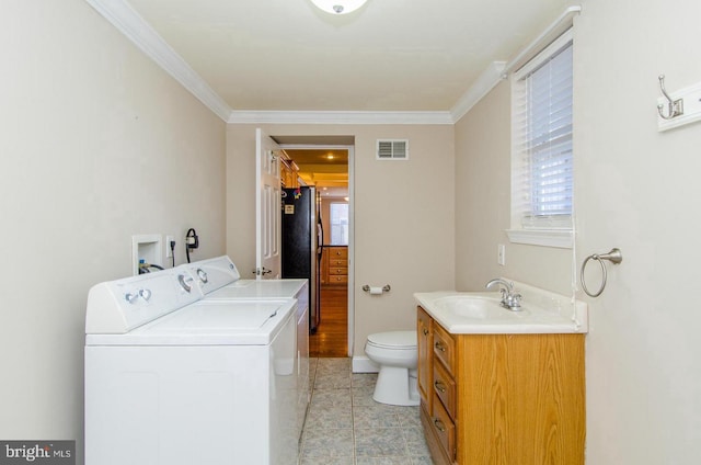 laundry area with washer and clothes dryer, light tile patterned floors, ornamental molding, and sink