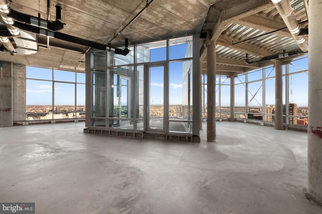 miscellaneous room featuring a towering ceiling and concrete floors