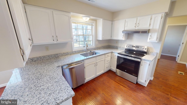 kitchen featuring sink, light stone counters, appliances with stainless steel finishes, dark hardwood / wood-style flooring, and white cabinetry