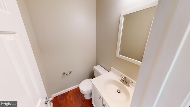 bathroom featuring vanity, wood-type flooring, and toilet