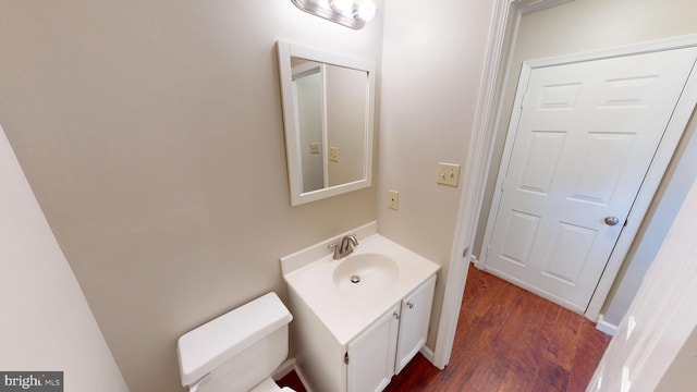 bathroom featuring toilet, vanity, and hardwood / wood-style flooring