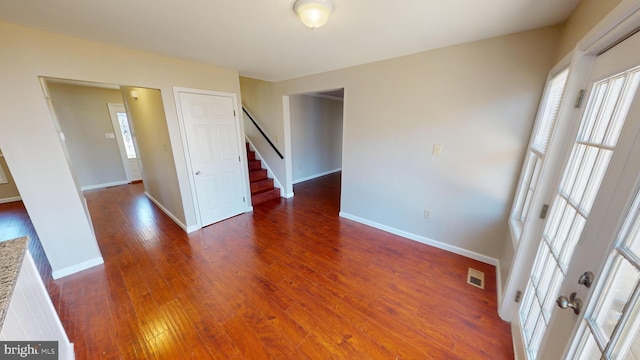 spare room featuring a wealth of natural light and dark hardwood / wood-style flooring