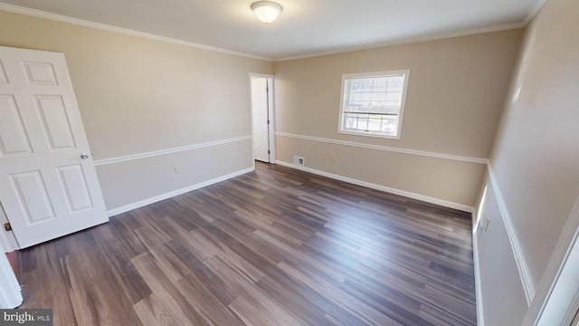 spare room with ornamental molding and dark wood-type flooring