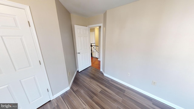 unfurnished bedroom with dark hardwood / wood-style flooring