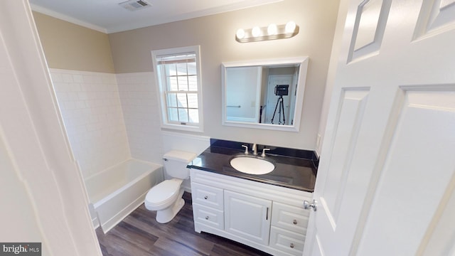 full bathroom featuring hardwood / wood-style floors, vanity, bathtub / shower combination, crown molding, and toilet