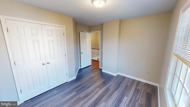 unfurnished bedroom featuring dark hardwood / wood-style floors and a closet