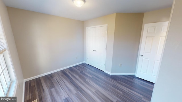 unfurnished bedroom featuring dark hardwood / wood-style flooring and a closet