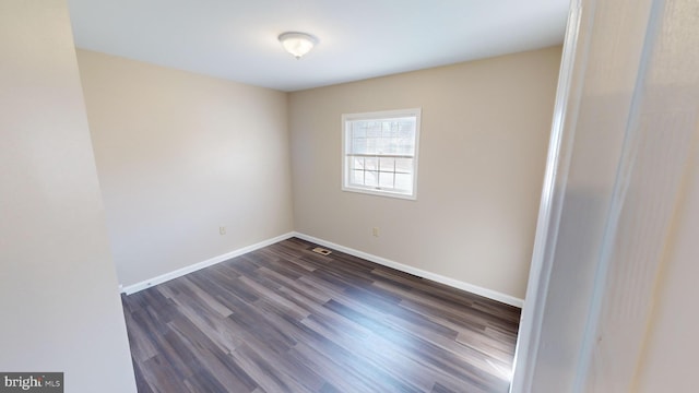 empty room with dark hardwood / wood-style flooring