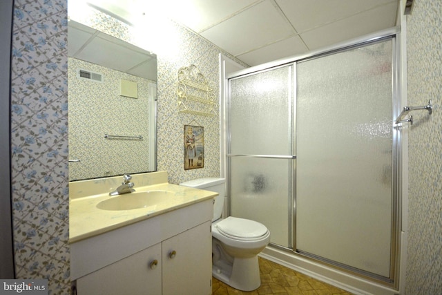 bathroom featuring vanity, a paneled ceiling, toilet, and an enclosed shower