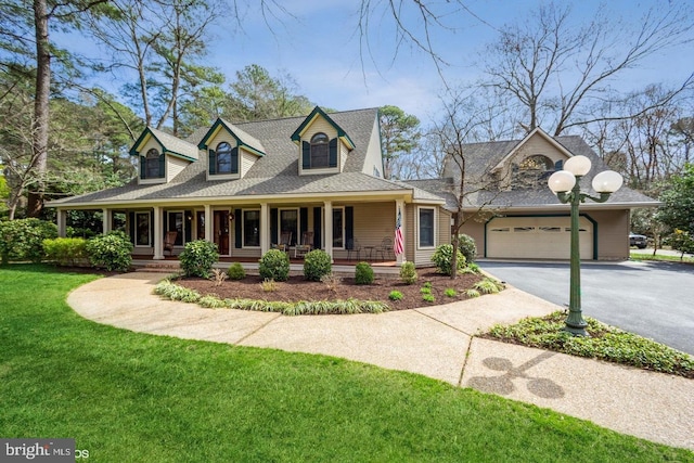 view of front facade featuring a front yard, a porch, and a garage