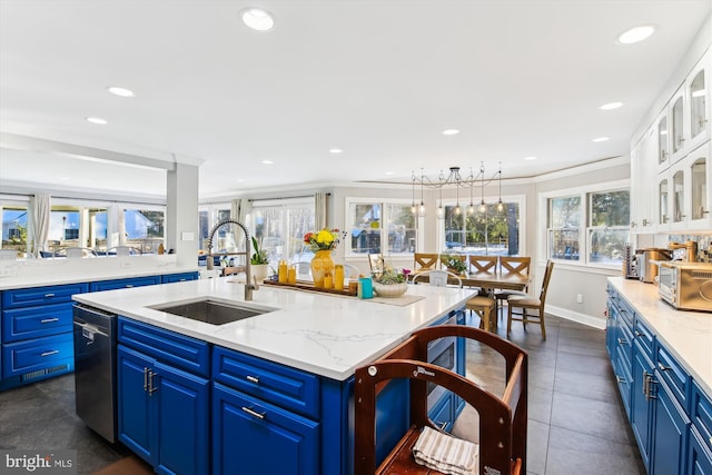 kitchen featuring a kitchen island with sink, blue cabinets, sink, ornamental molding, and white cabinetry