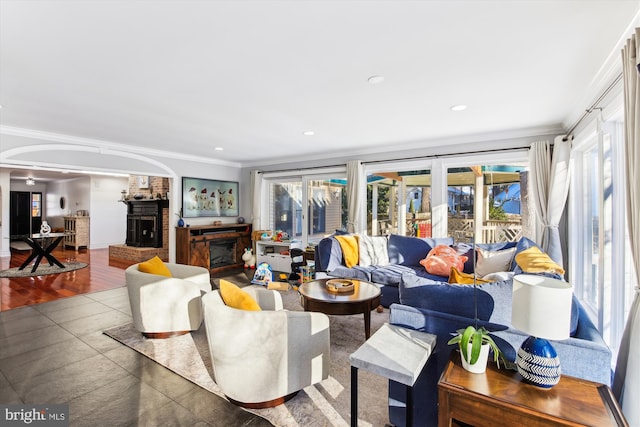 tiled living room featuring a fireplace, a healthy amount of sunlight, and ornamental molding