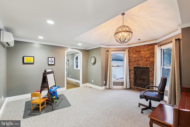 interior space with an inviting chandelier, a stone fireplace, crown molding, and a wall mounted AC