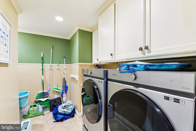 washroom with washer and clothes dryer, light tile patterned flooring, cabinets, and crown molding