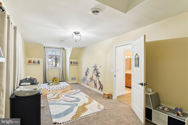 bedroom featuring light colored carpet and connected bathroom