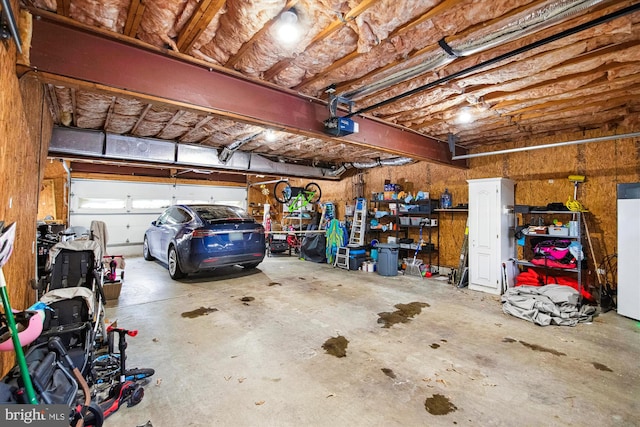 garage with a garage door opener and white refrigerator