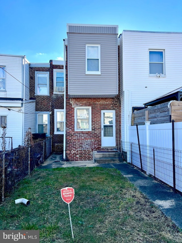 rear view of property with cooling unit and a yard