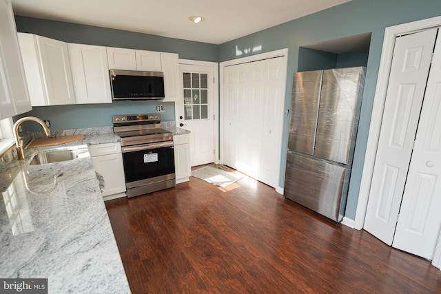 kitchen with white cabinets, stainless steel appliances, and dark wood-type flooring