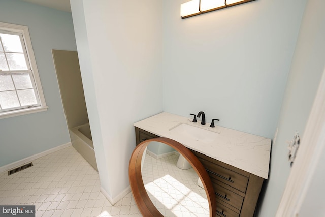 bathroom with a bathtub, tile patterned flooring, and vanity