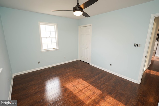 unfurnished bedroom with ceiling fan, a closet, and dark hardwood / wood-style floors