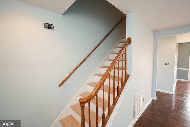 staircase with hardwood / wood-style floors